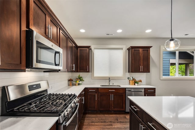 kitchen featuring a sink, appliances with stainless steel finishes, backsplash, and light countertops