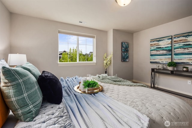 bedroom featuring baseboards, carpet flooring, and visible vents