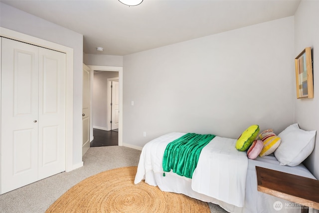 bedroom with a closet, baseboards, and carpet flooring