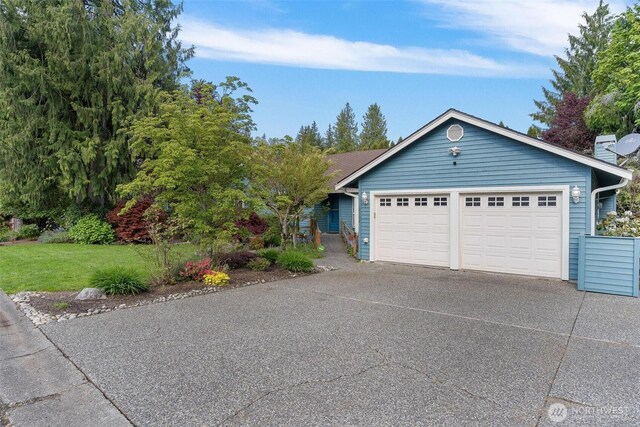 ranch-style house with an attached garage, driveway, and a front lawn