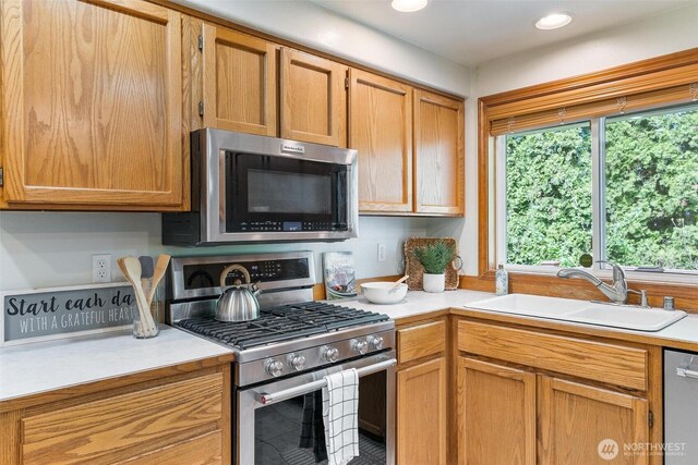 kitchen with a sink, appliances with stainless steel finishes, recessed lighting, and light countertops