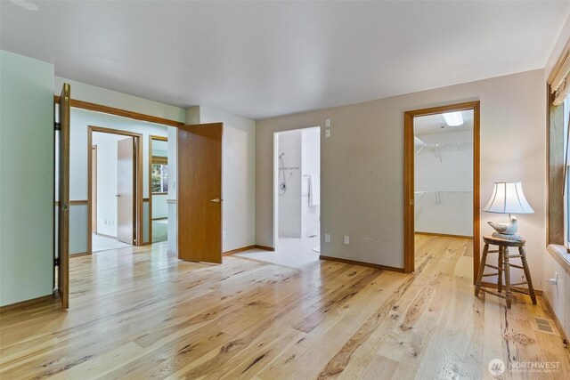 unfurnished room featuring visible vents, baseboards, and light wood-type flooring