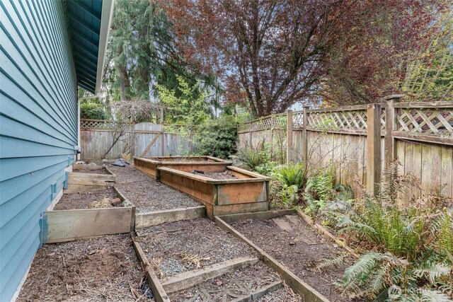 view of yard with a garden and a fenced backyard
