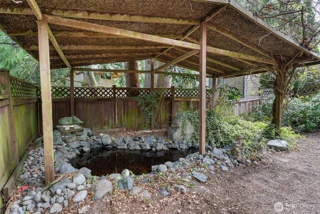 exterior space featuring a fenced backyard and a garden pond