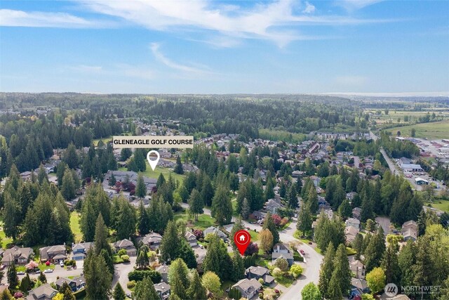 drone / aerial view with a residential view and a view of trees