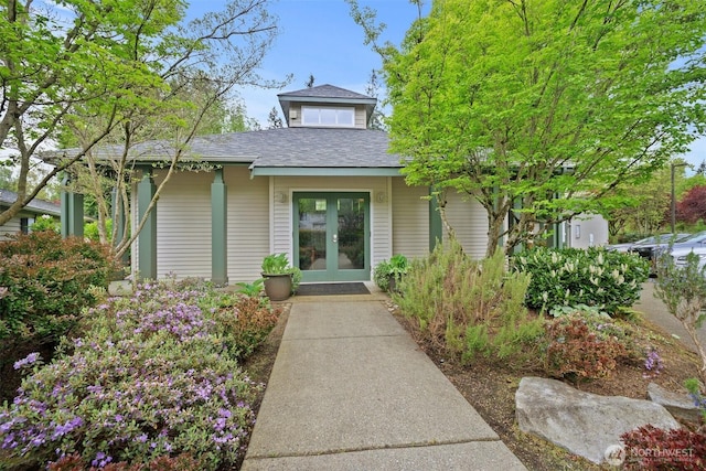 property entrance featuring french doors and a shingled roof