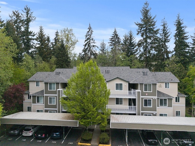 view of building exterior with covered and uncovered parking