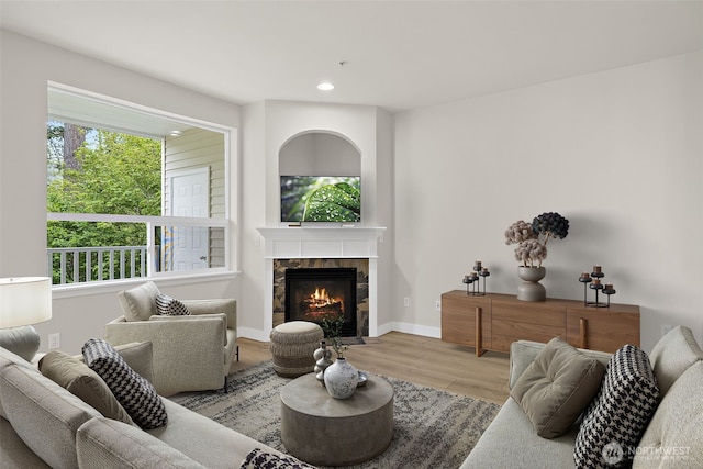 living room with recessed lighting, baseboards, wood finished floors, and a tile fireplace