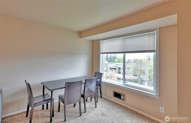 carpeted dining space with baseboards and visible vents