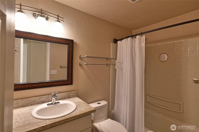 bathroom featuring a textured ceiling, vanity, toilet, shower / tub combo with curtain, and a textured wall