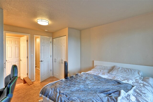 bedroom with a closet, carpet flooring, and a textured ceiling
