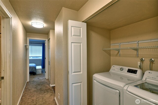 clothes washing area featuring laundry area, a textured wall, dark carpet, a textured ceiling, and separate washer and dryer