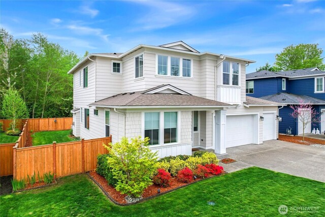 traditional home featuring fence, an attached garage, a shingled roof, a front lawn, and concrete driveway