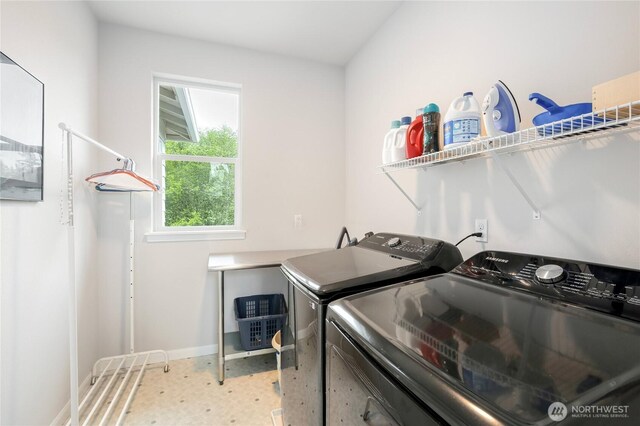 washroom with baseboards, laundry area, and washer and clothes dryer