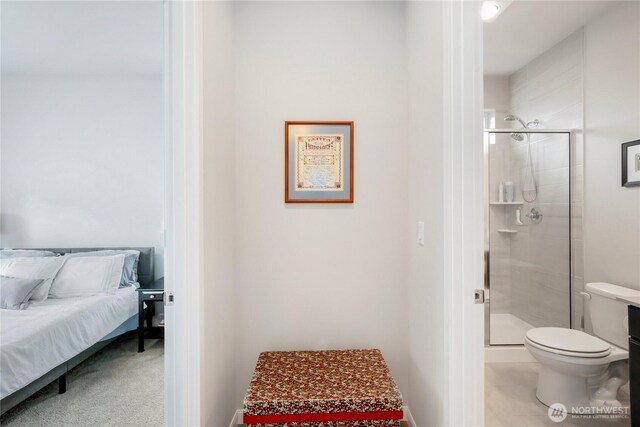 ensuite bathroom featuring toilet, a shower stall, and ensuite bathroom