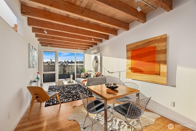 115 E Allison St, Seattle, WA 98102 - dining room with an AC wall unit, baseboards, beam ceiling, and wood finished floors