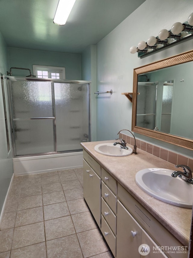 full bath with a sink, baseboards, enclosed tub / shower combo, and double vanity