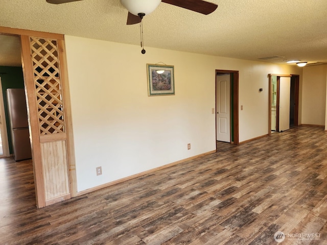interior space featuring dark wood-style flooring, a textured ceiling, a ceiling fan, and baseboards