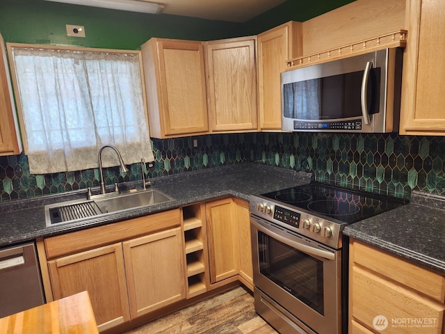 kitchen featuring backsplash, stainless steel appliances, a sink, and light brown cabinets