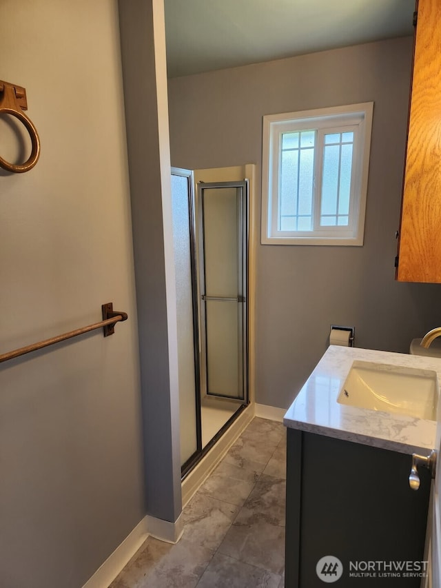 bathroom with vanity, baseboards, a stall shower, and marble finish floor