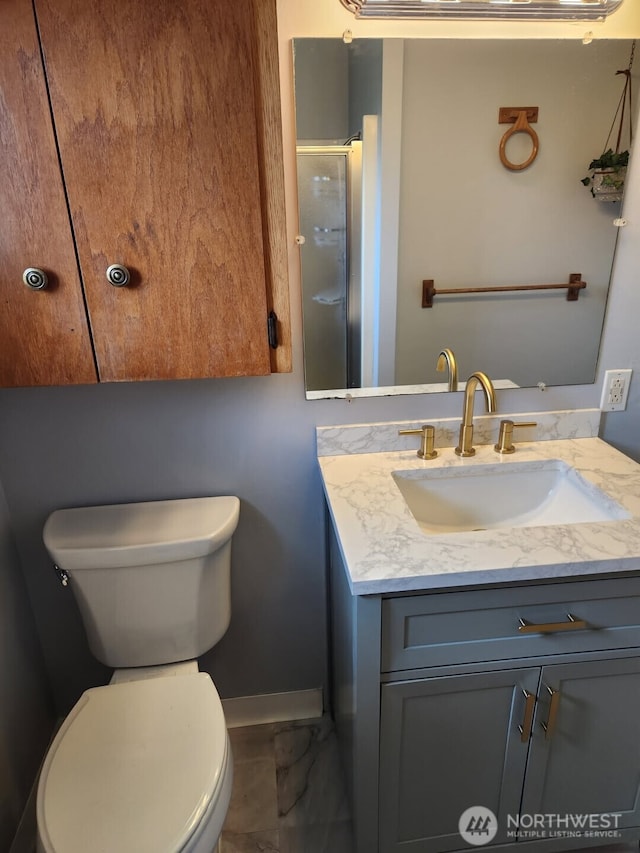 full bathroom with a shower with shower door, vanity, toilet, marble finish floor, and baseboards