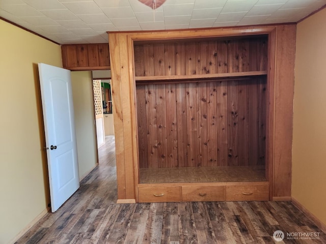 mudroom featuring baseboards, wood walls, and wood finished floors
