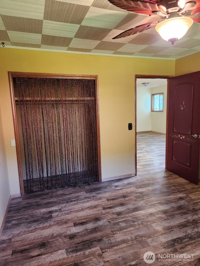 empty room featuring baseboards, ceiling fan, and wood finished floors