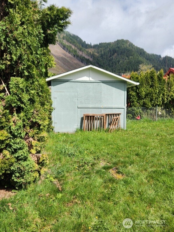 view of shed with a mountain view and fence