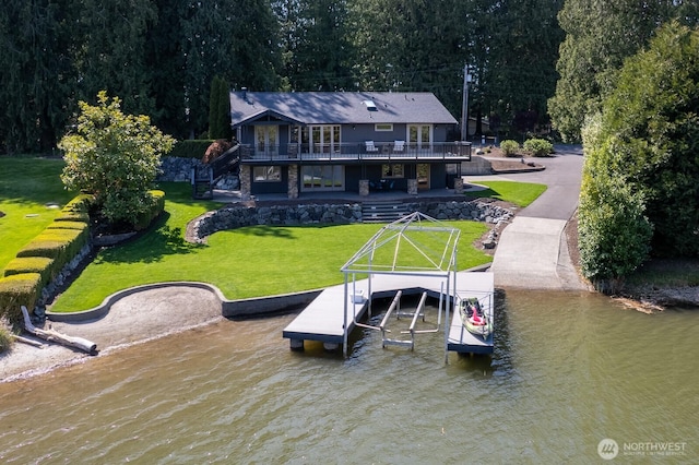 exterior space featuring a lawn, boat lift, and a deck with water view