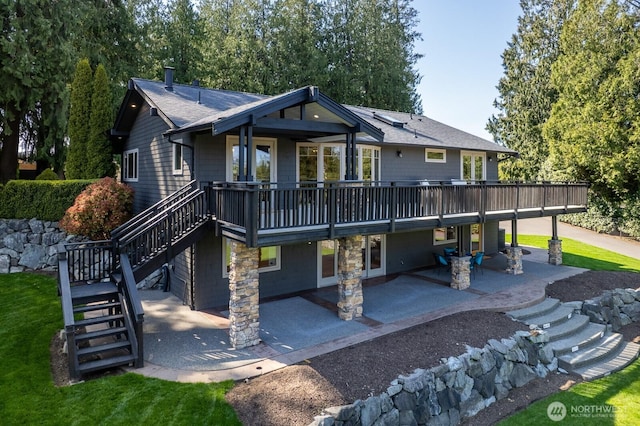 rear view of property with roof with shingles, a patio, a deck, and stairway