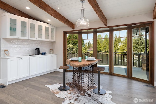 dining space featuring lofted ceiling with beams, recessed lighting, wood finished floors, and visible vents