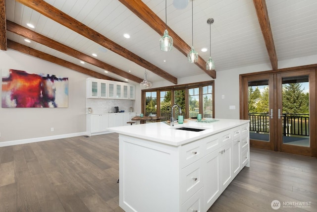 kitchen with a kitchen island with sink, wood finished floors, recessed lighting, french doors, and a sink