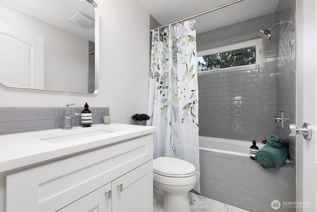 full bathroom featuring vanity, tiled shower / bath, toilet, and marble finish floor
