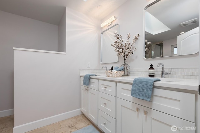 bathroom with a sink, baseboards, and double vanity