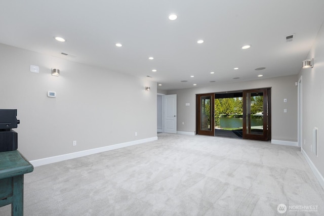 unfurnished living room featuring light colored carpet, recessed lighting, baseboards, and visible vents