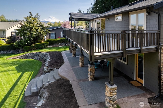 view of yard featuring a patio and a deck with mountain view