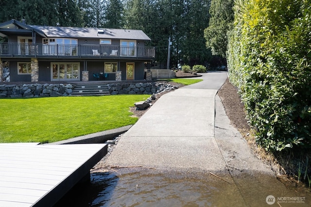 back of property featuring a lawn and a wooden deck