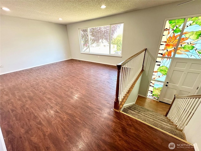 entryway with wood finished floors, baseboards, stairway, recessed lighting, and a textured ceiling