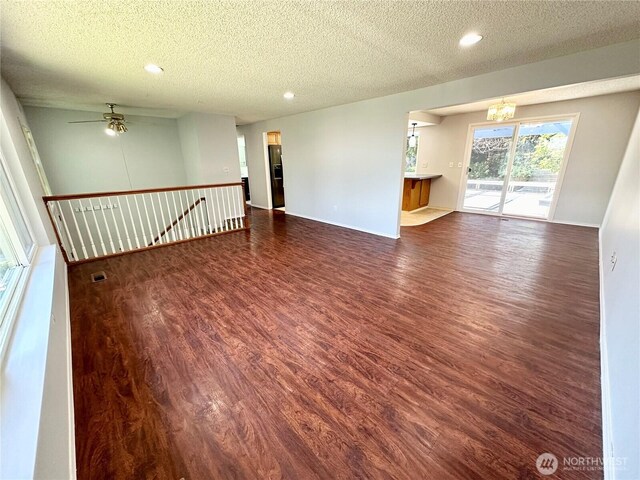 spare room featuring a textured ceiling, visible vents, wood finished floors, ceiling fan with notable chandelier, and recessed lighting
