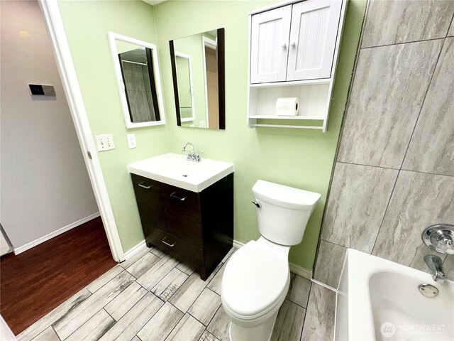 full bathroom featuring vanity, baseboards, toilet, and wood finished floors