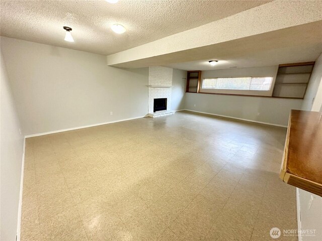 unfurnished living room with a textured ceiling, baseboards, tile patterned floors, and a fireplace