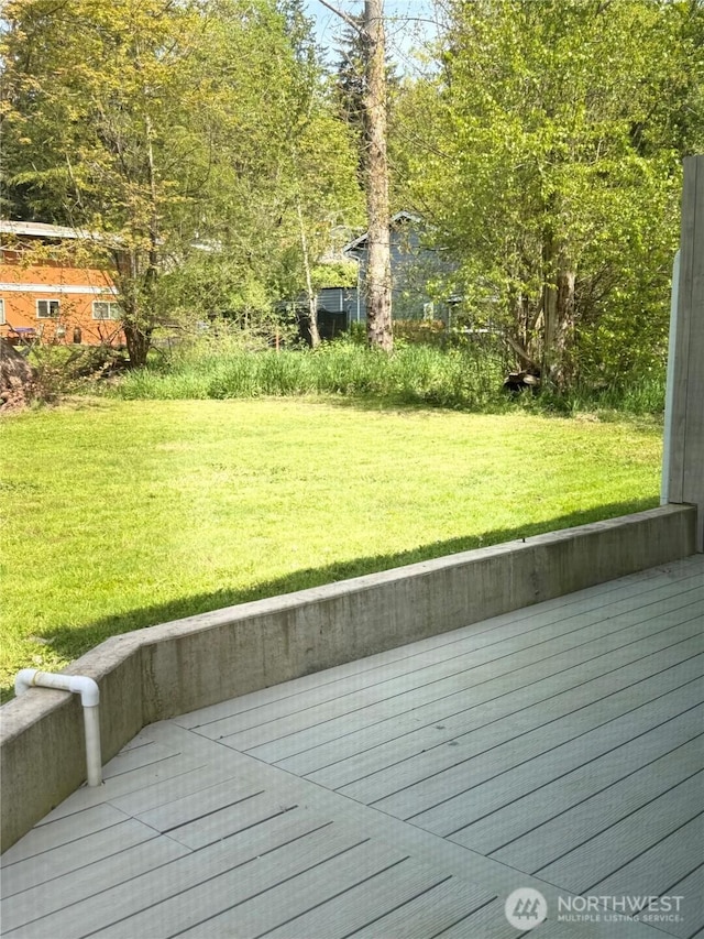 wooden terrace featuring a lawn