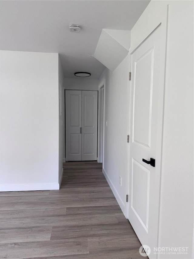 hallway with baseboards and wood finished floors
