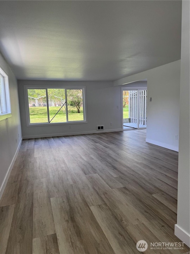 empty room featuring baseboards and wood finished floors