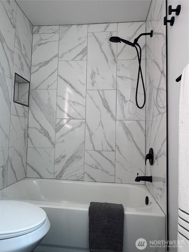 bathroom with washtub / shower combination and toilet