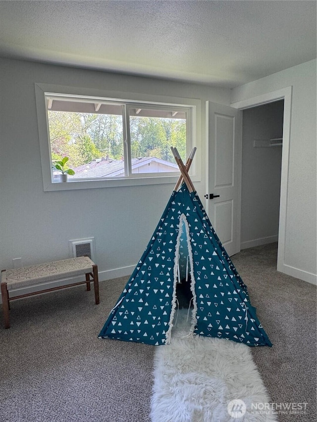 rec room with carpet floors, a textured ceiling, and baseboards