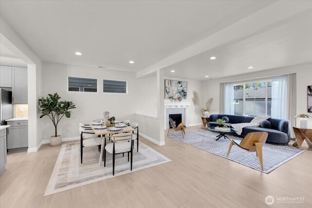living room featuring a fireplace, recessed lighting, baseboards, and light wood-type flooring