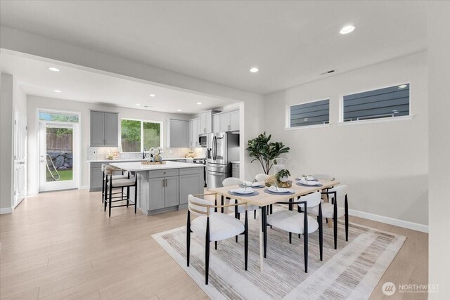 dining area with recessed lighting, light wood-style flooring, and baseboards