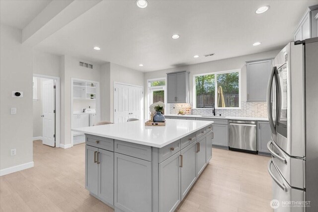 kitchen featuring gray cabinetry, appliances with stainless steel finishes, recessed lighting, and visible vents