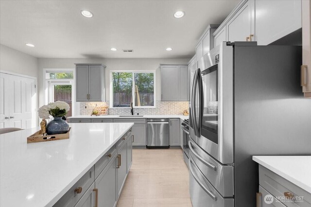 kitchen with light countertops, gray cabinetry, and appliances with stainless steel finishes